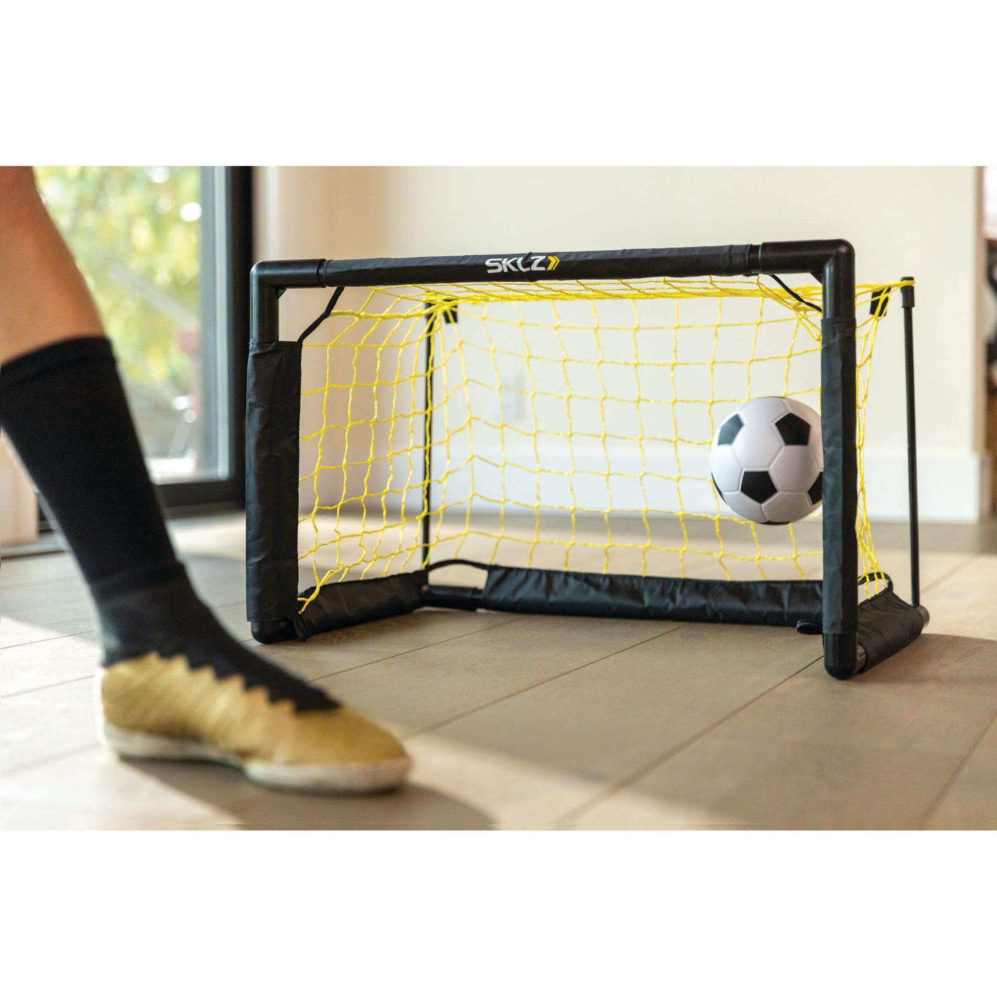 Soccer ball moves into goal net in indoor space during practice or game