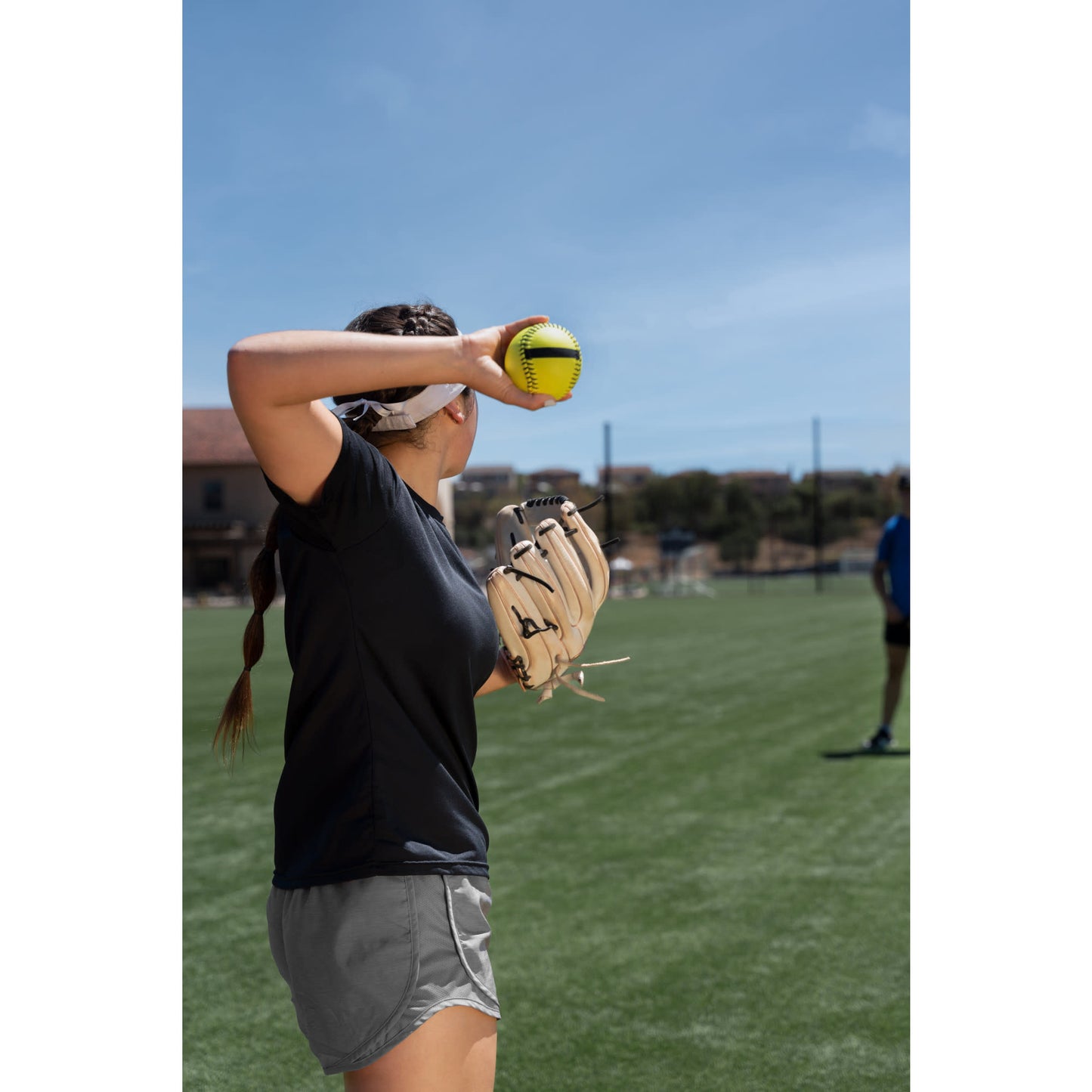 Girl prepares to throw a softball on a field during practice