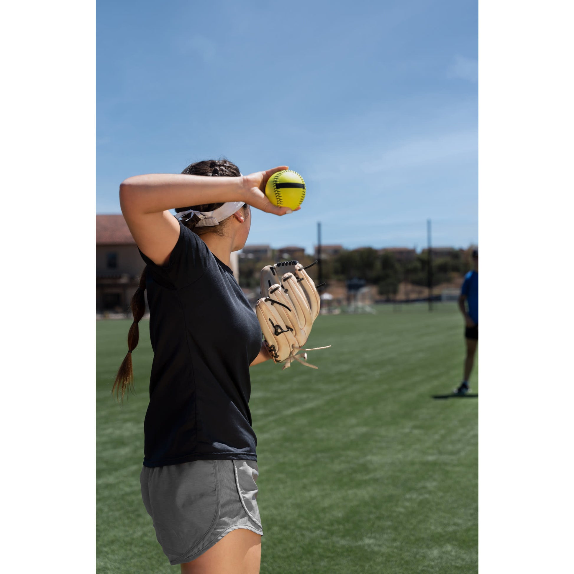 Girl prepares to throw a softball on a field during practice