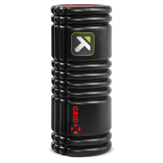 The foam roller compresses muscles in a gym environment for muscle relief and recovery.
