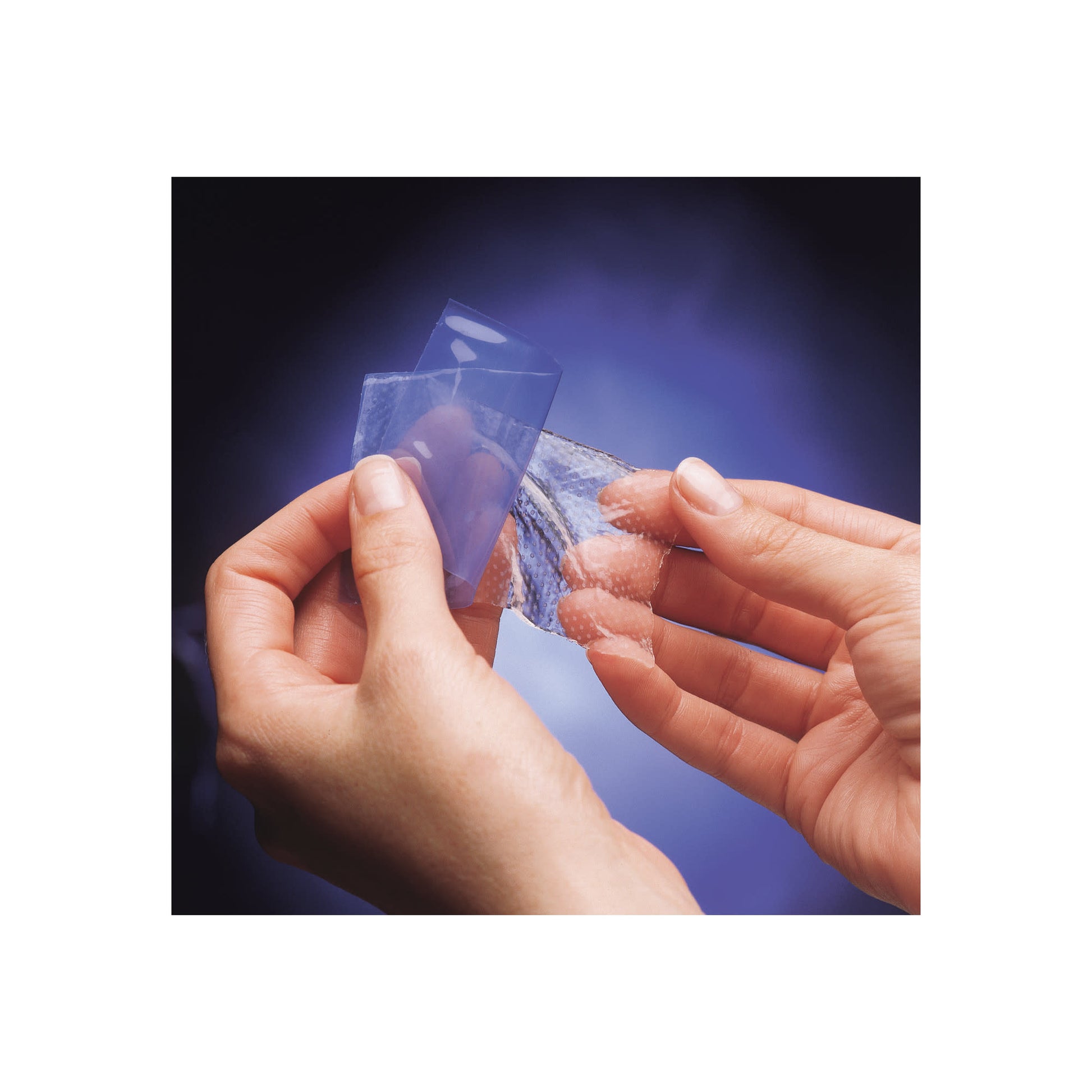 Hands peel a blister pack in a dark environment