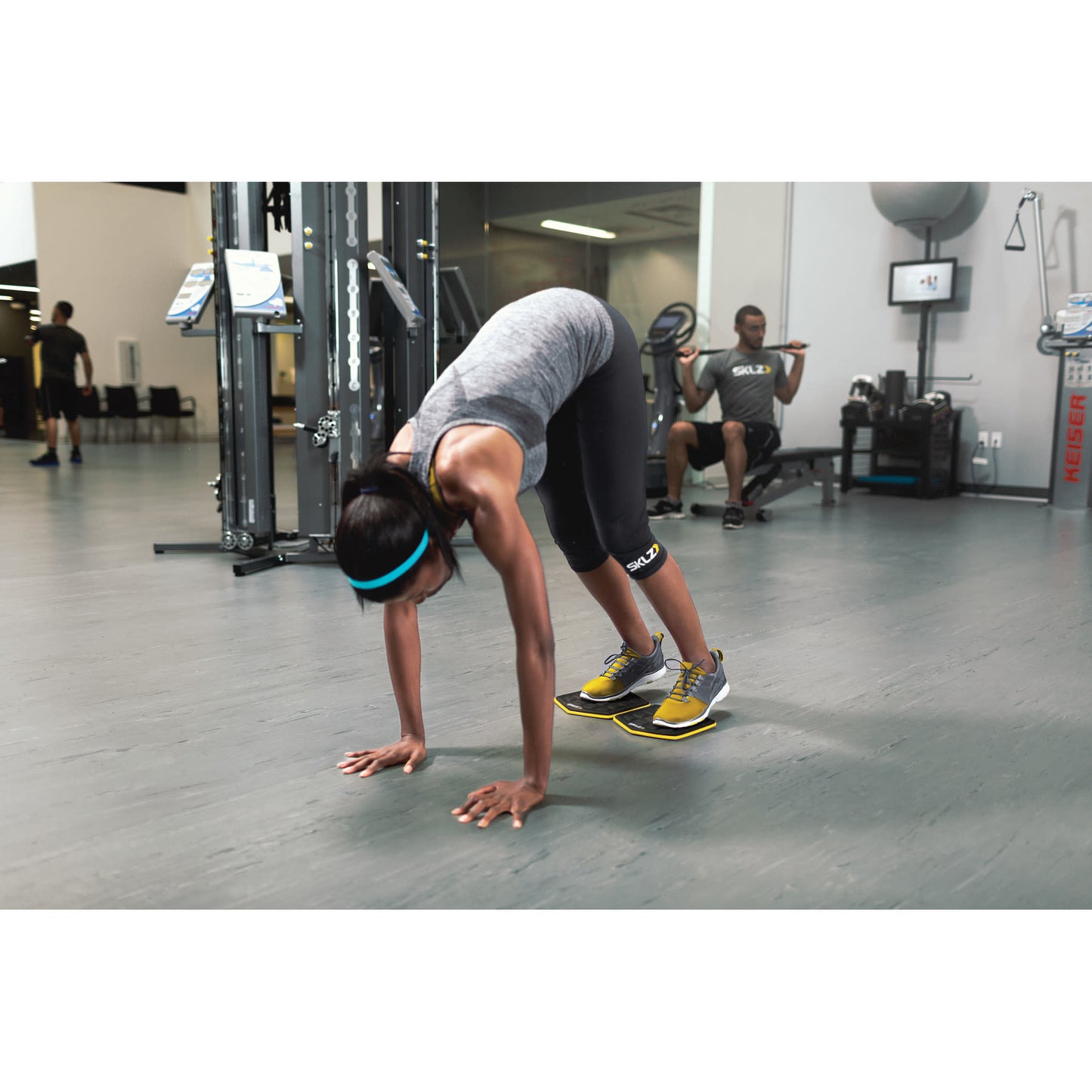 Woman performs mountain climbers on a slide board in a gym environment