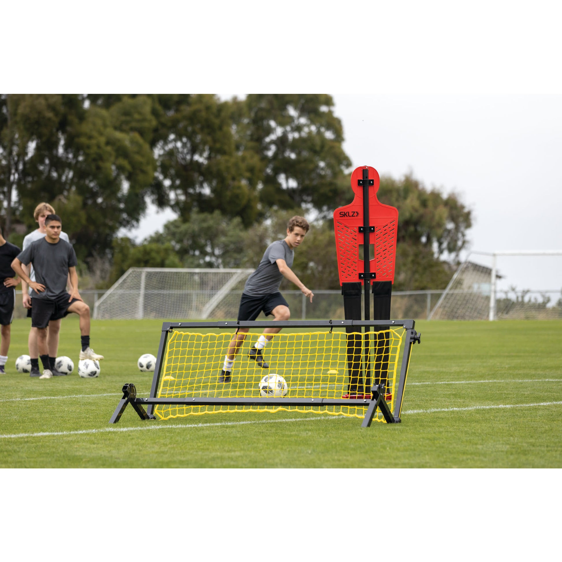 A boy kicks a soccer ball over a training obstacle during a soccer practice on a field