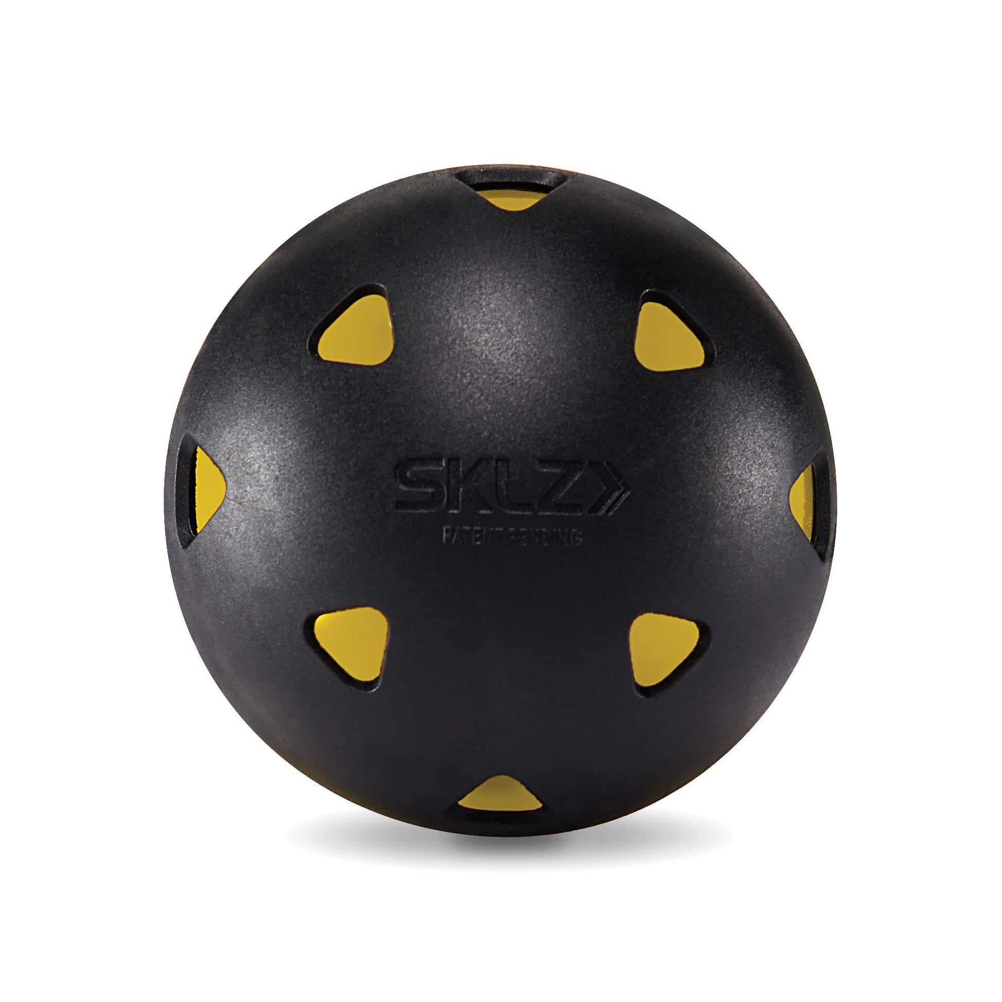 A black balance ball with yellow cutouts rests on a plain white surface