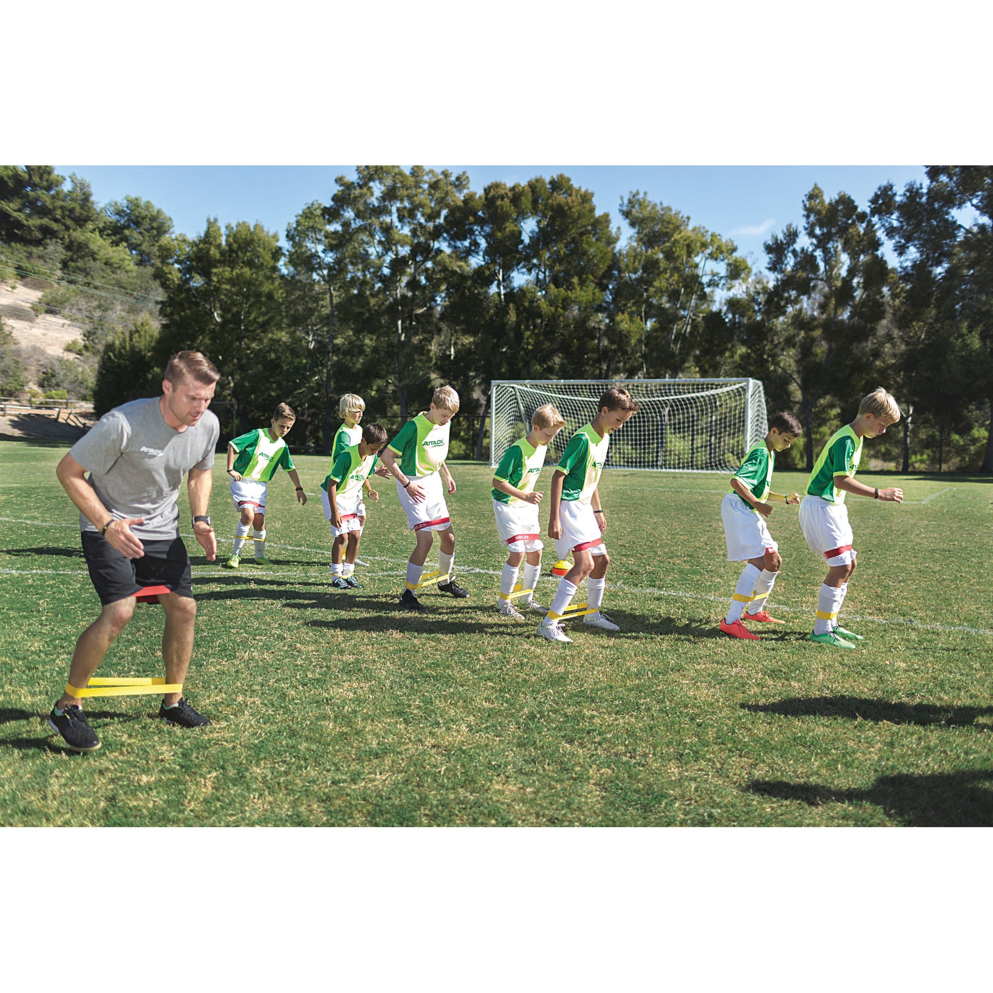 Young soccer players train during a practice session on a grassy field under a clear sky
