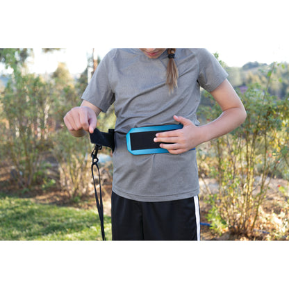Child adjusts an activity belt outdoors in a garden or park setting