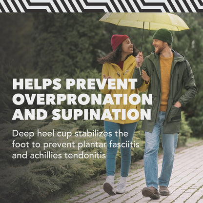 Couple walks under umbrella, smiling and chatting, in a park with lush greenery.