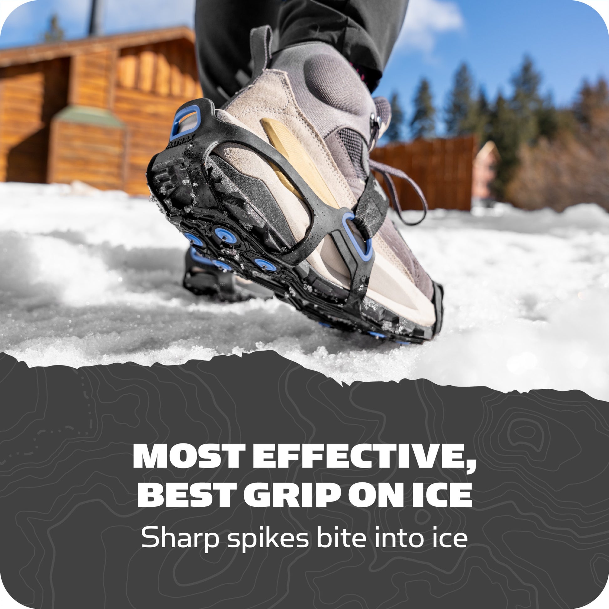 Shoe grips ice with spiked sole outdoors near wooden cabin and trees.