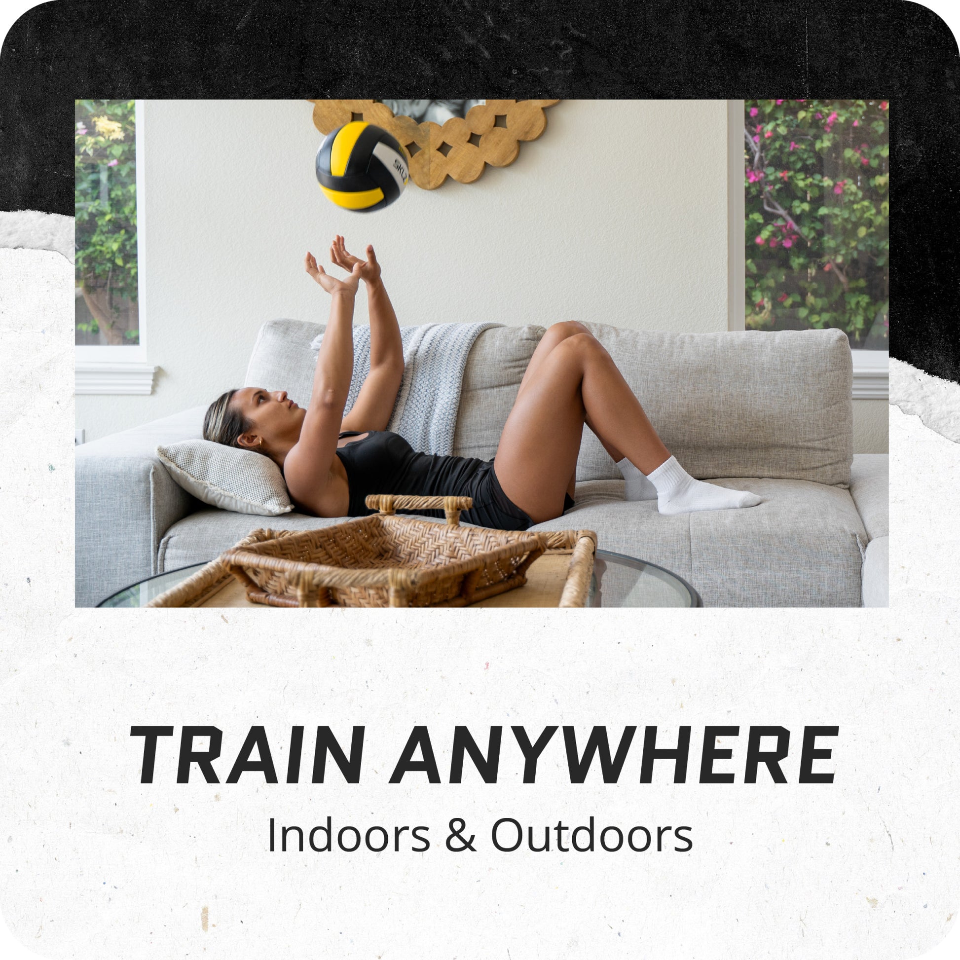 Woman practices volleyball indoors on a sofa in a living room environment