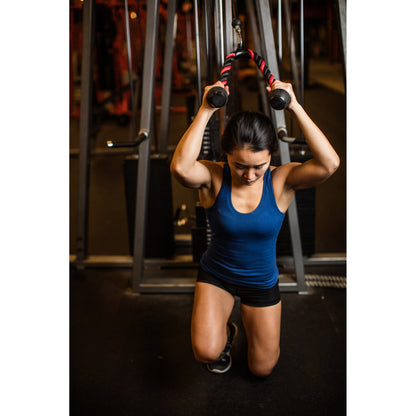 Person kneeling, pulling cable, focused in gym setting.