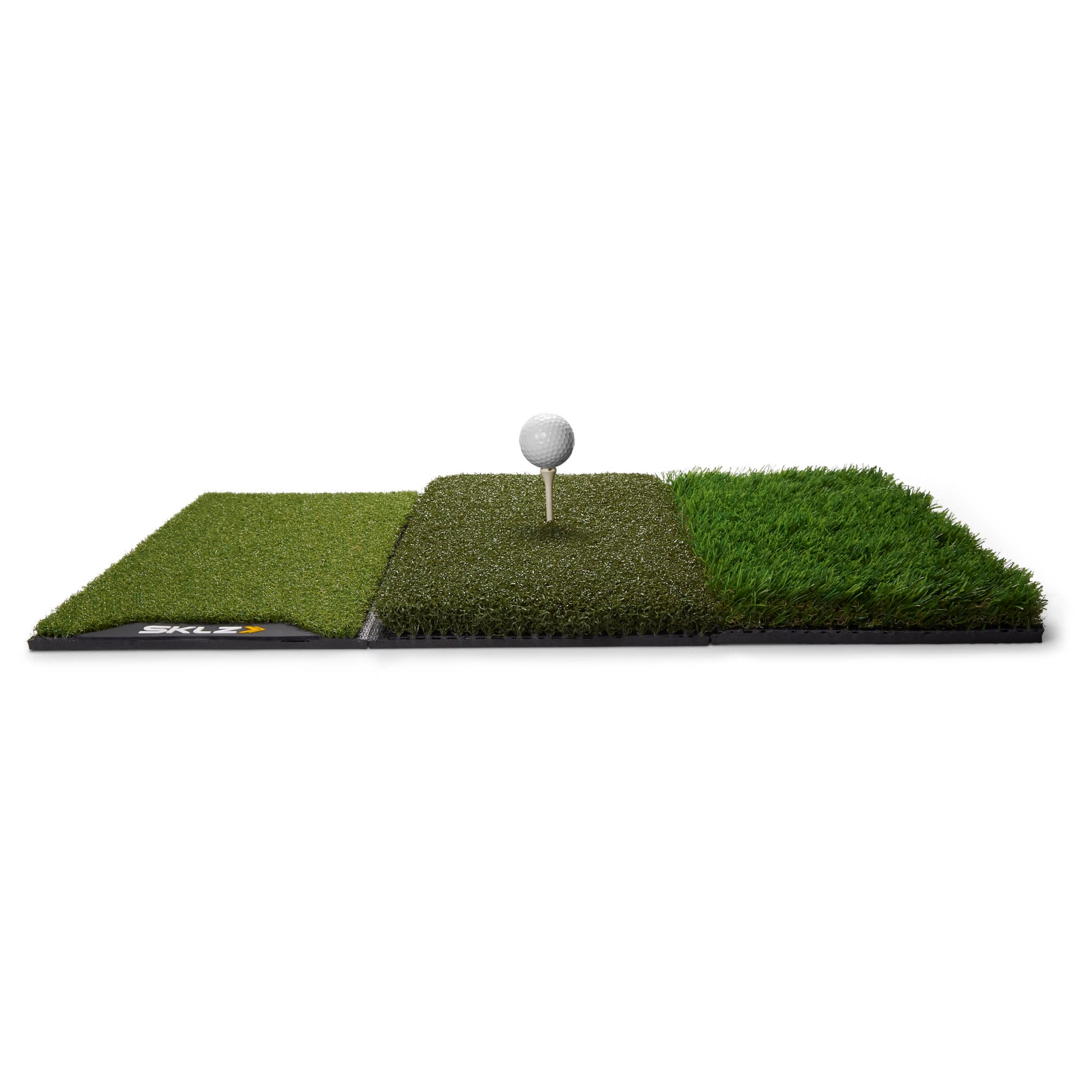 A golf tee and ball on three different grass mats for turf testing or practice