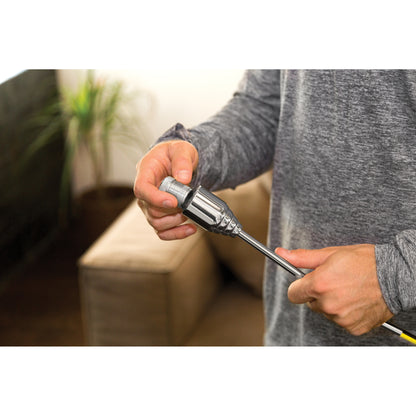 Person holds a soldering iron in a workshop or home environment