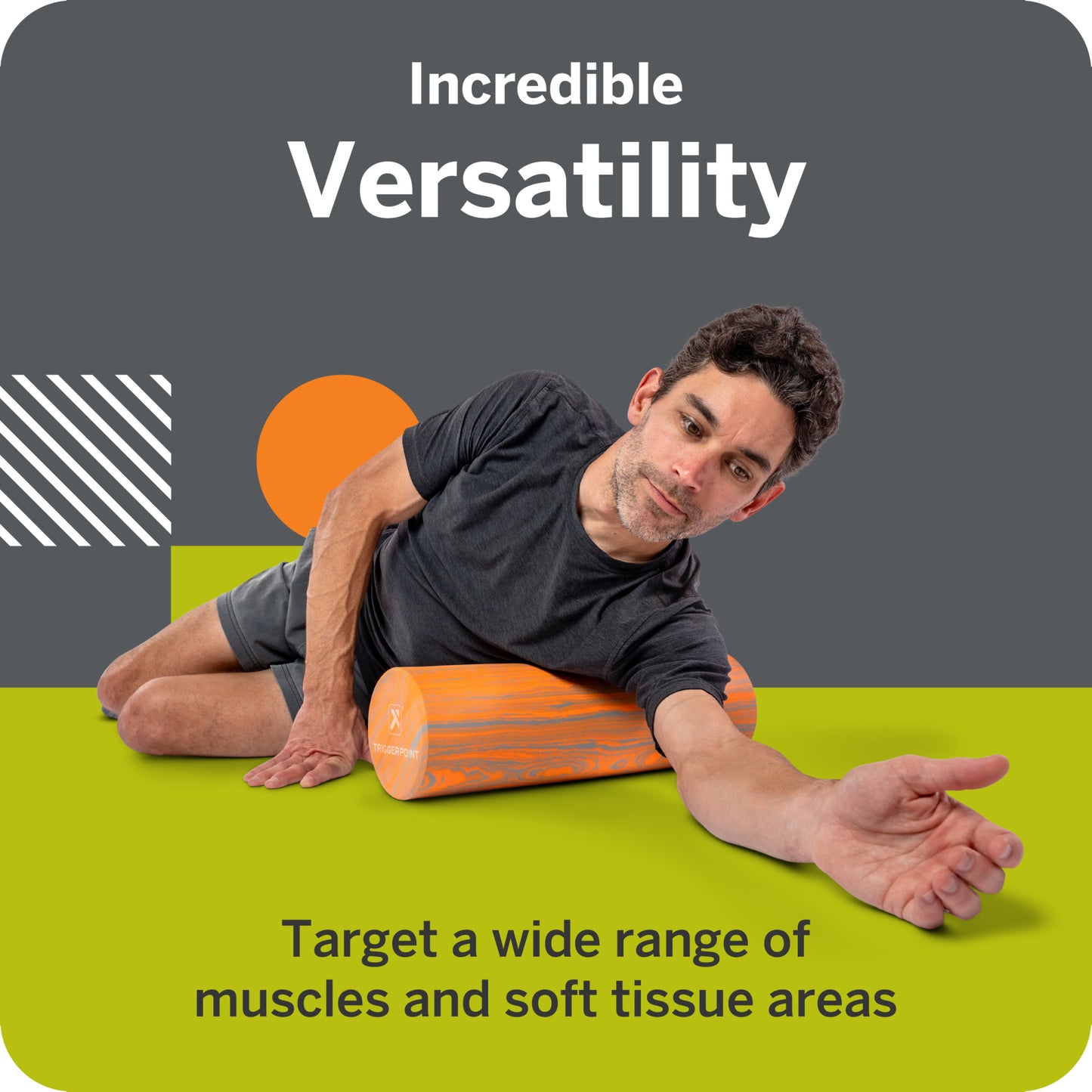 Man uses foam roller to target muscles on green floor in a gym setting.