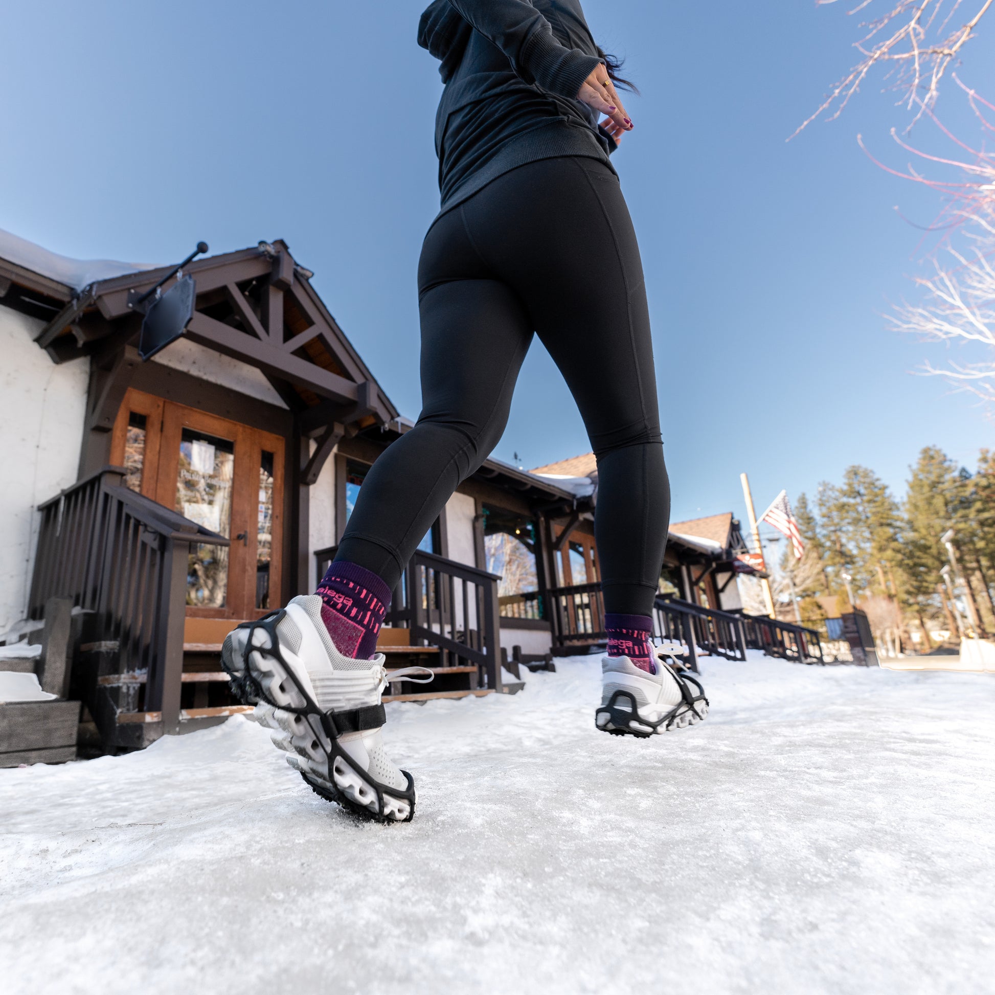 Person runs on snow outside a cabin in winter during daytime