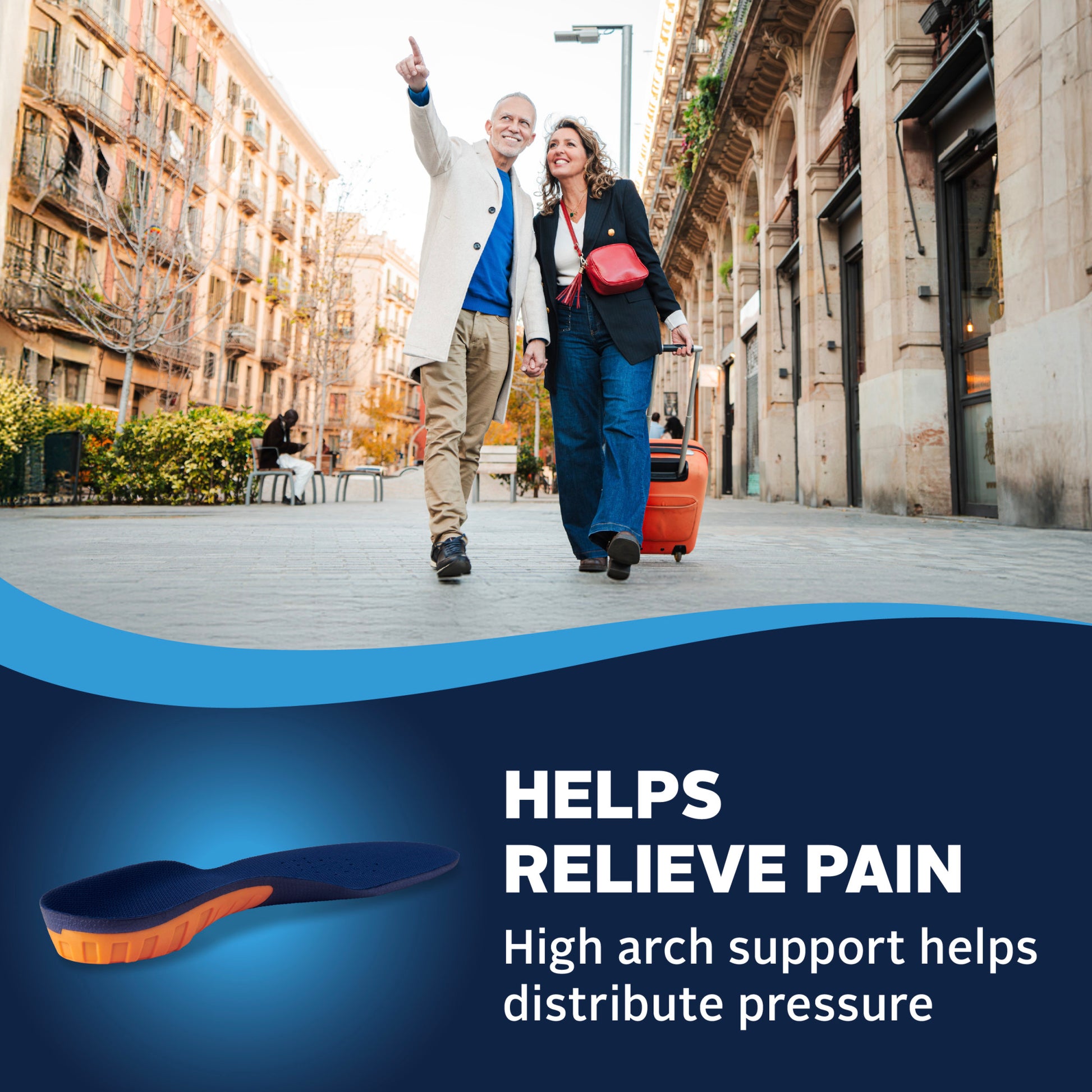 Couple walking with luggage in city street, smiling and pointing, advertisement for a shoe that relieves pain.