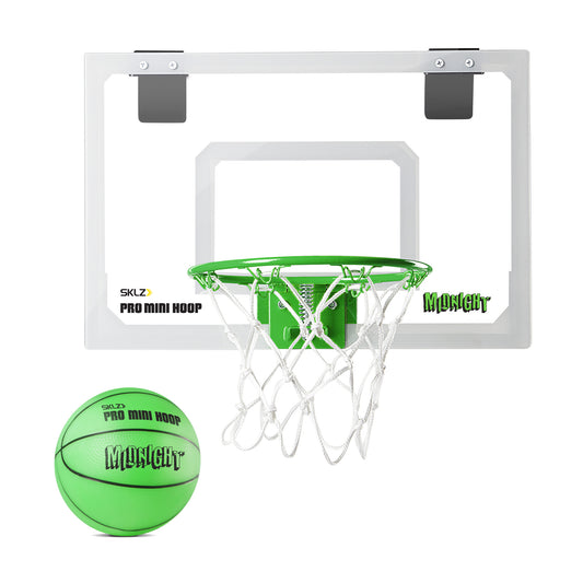 A green basketball is shot towards a white backboard with a hoop in indoor gym surroundings