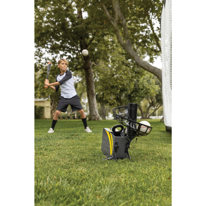 Boy practices baseball batting with a tee in a park during daytime