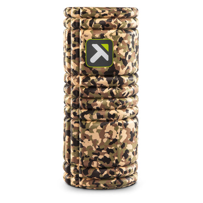 A camouflage-patterned foam roller balances vertically in a white space.