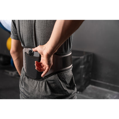Hand places remote in waist pouch on a person in a gym.