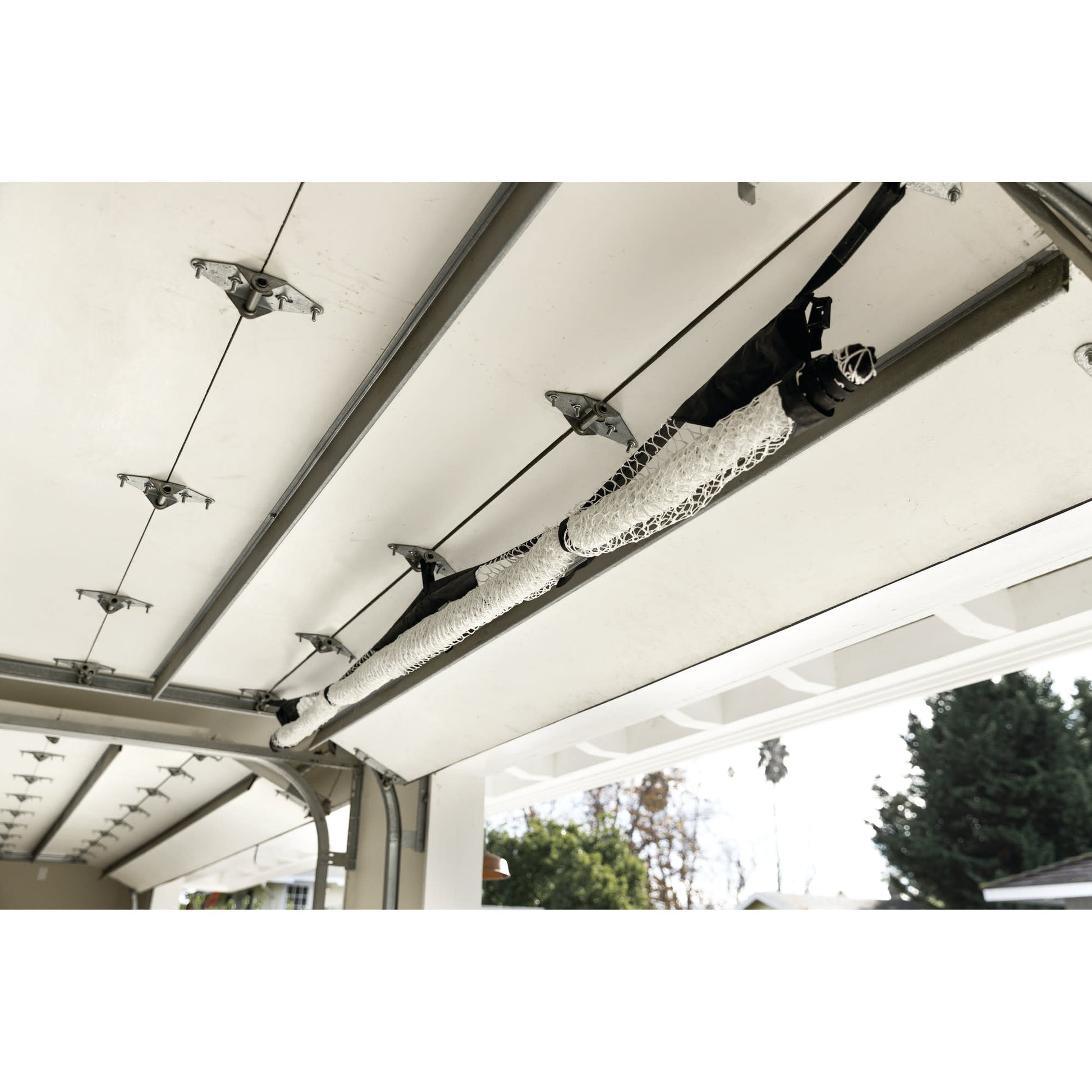 Clothes hang on a rail attached to a garage ceiling outdoors
