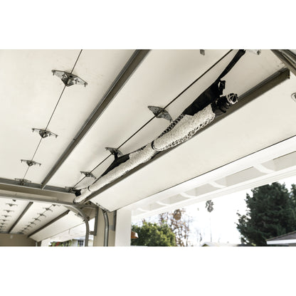 Clothes hang on a rail attached to a garage ceiling outdoors