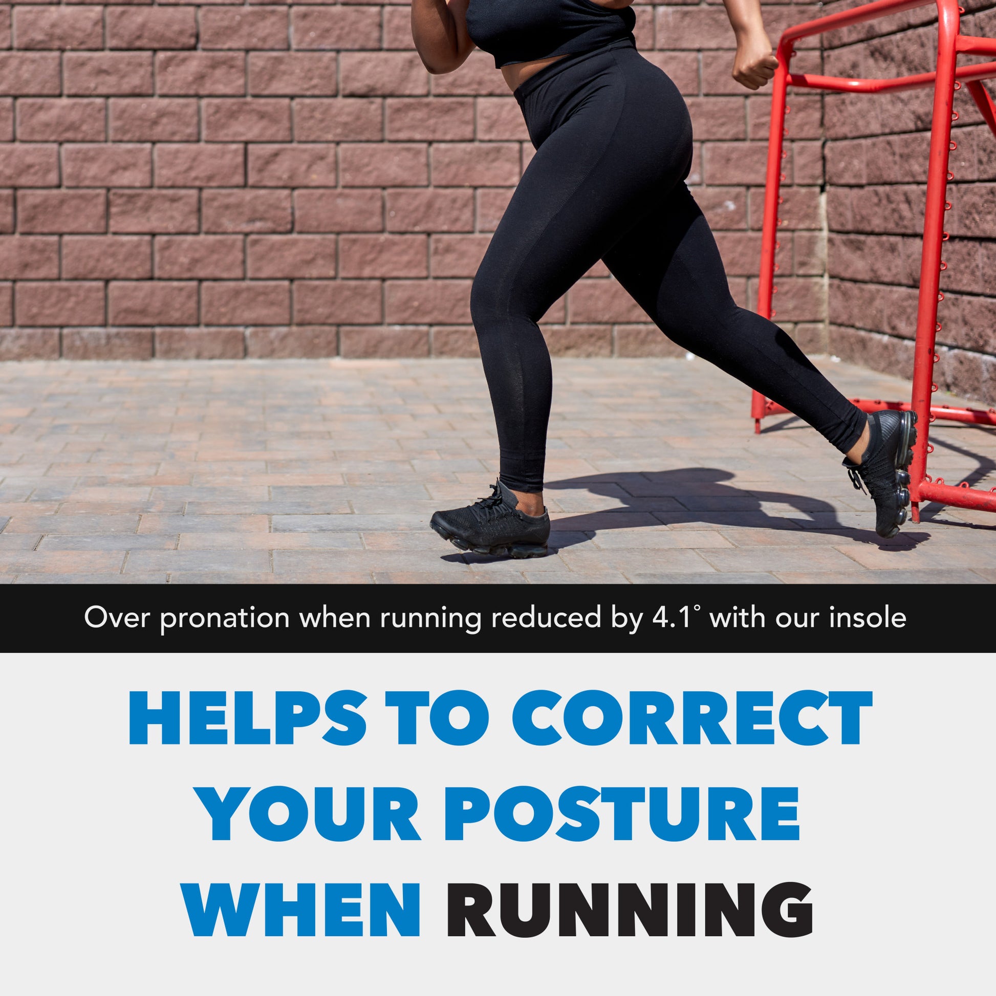 Runner moves forward on a paved path, next to a brick wall and red railing.