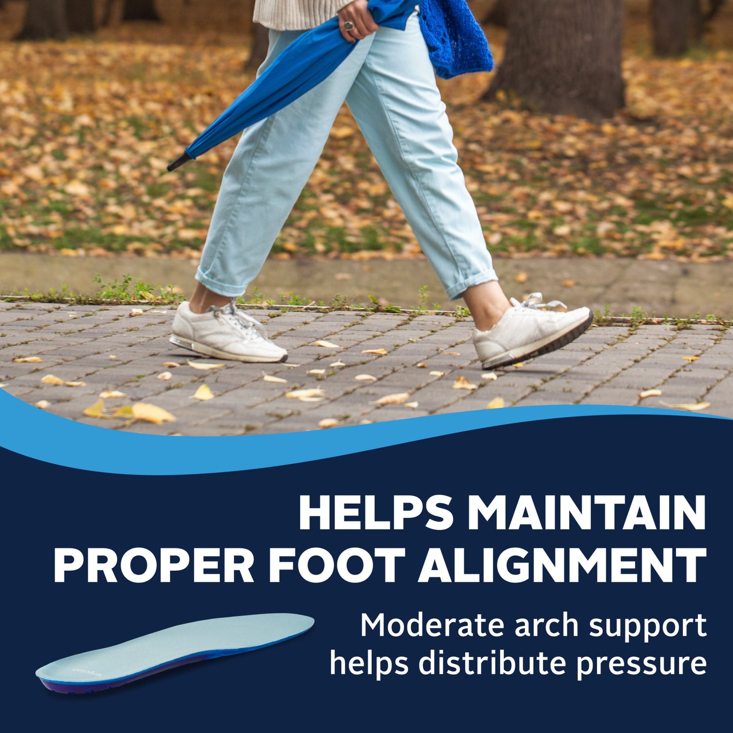 Person walks on cobblestone path carrying an umbrella, outdoor park setting with autumn leaves.