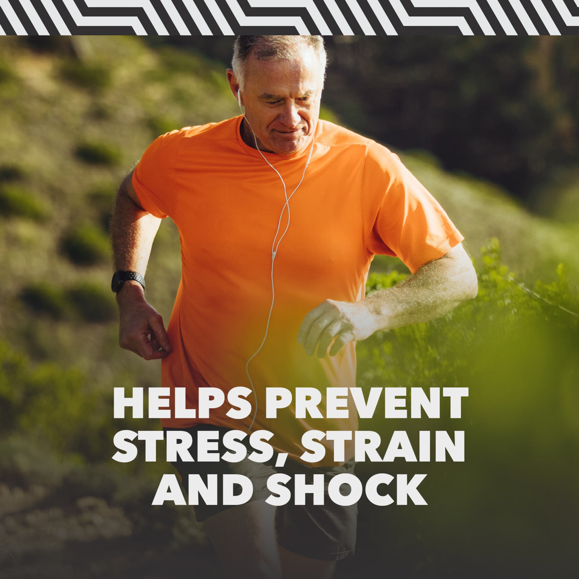 Man running outdoors on a trail wearing an orange shirt, surrounded by greenery.