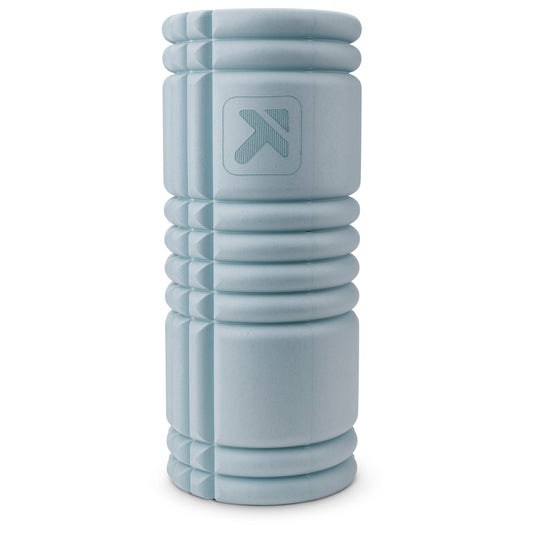 A light gray foam roller rests upright against a plain white background