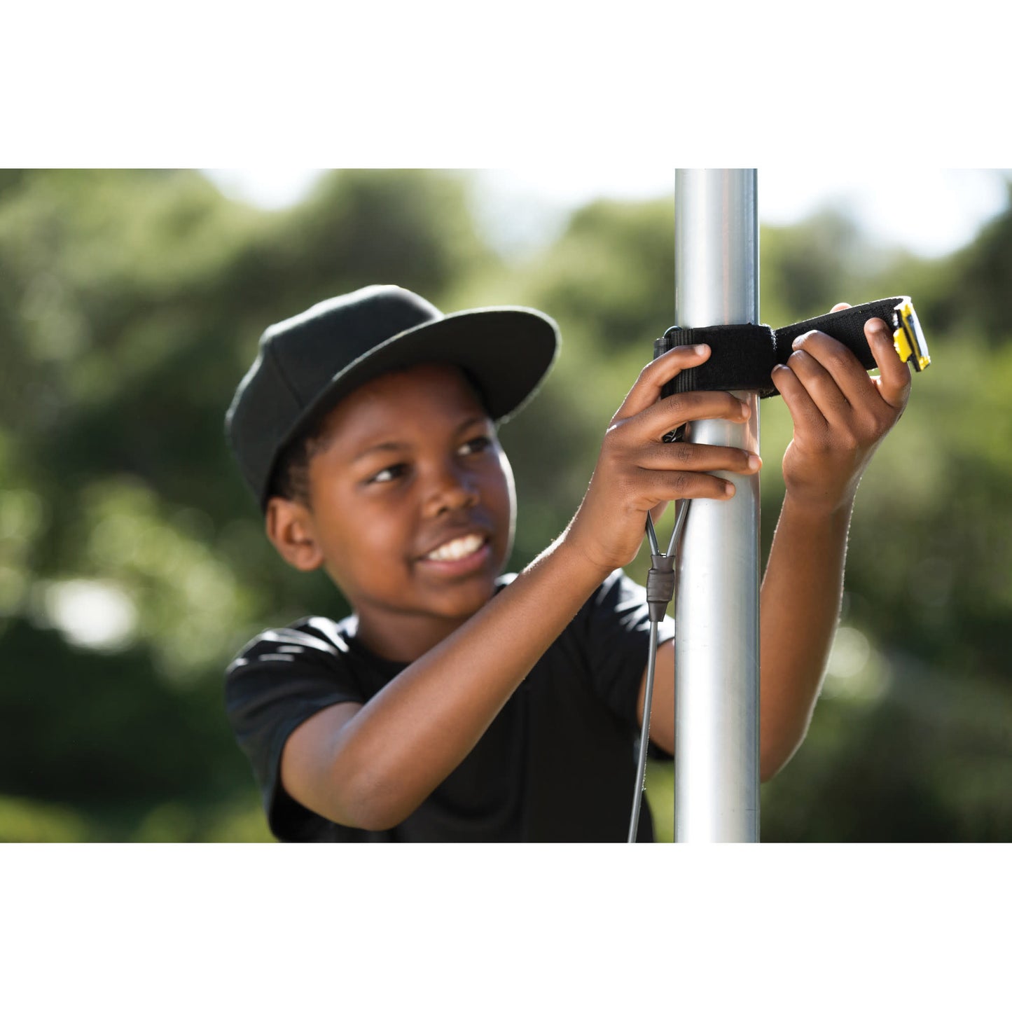 Child operates a device on a pole outdoors during daytime