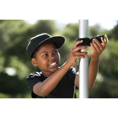 Child operates a device on a pole outdoors during daytime