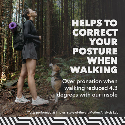 Woman with backpack gazes up in a forest, accompanied by a dog looking upward.