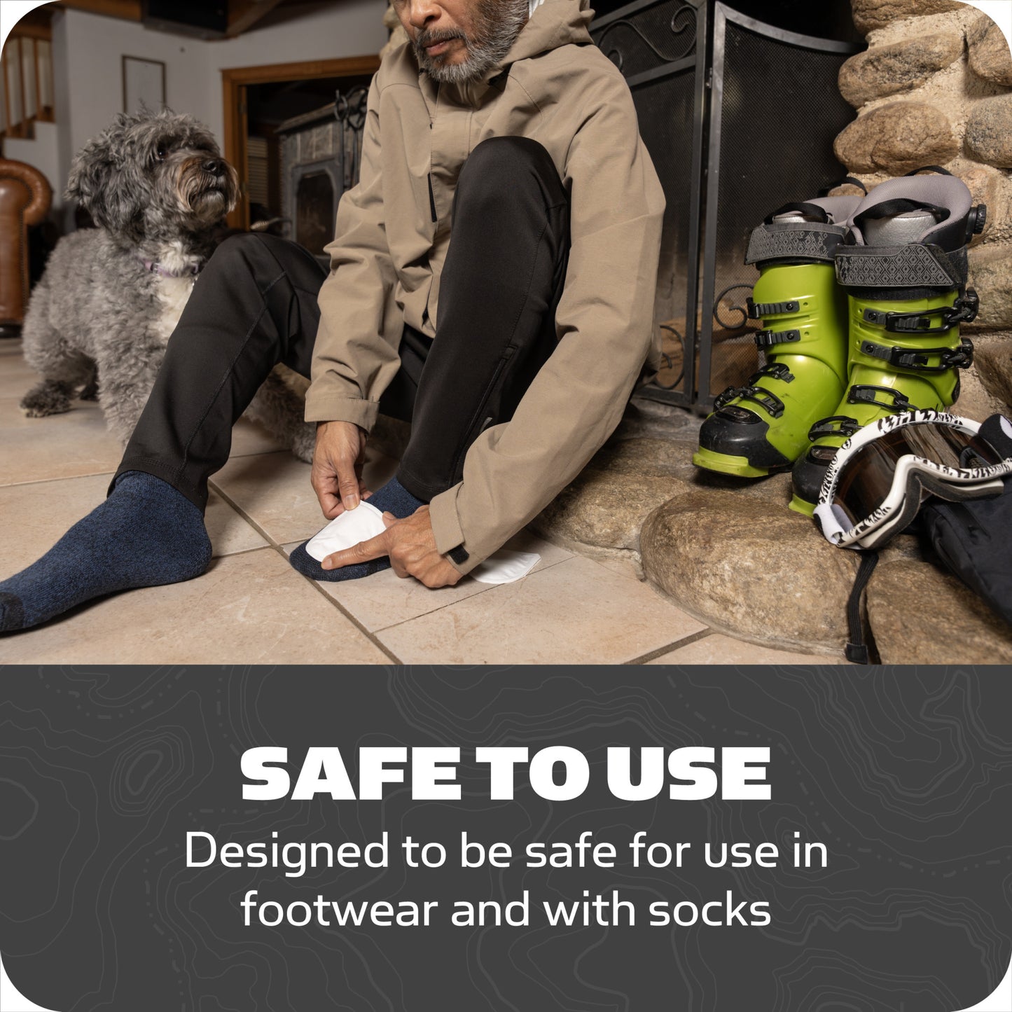 Man puts on sock in a living room with ski boots and dog nearby for footwear safety.