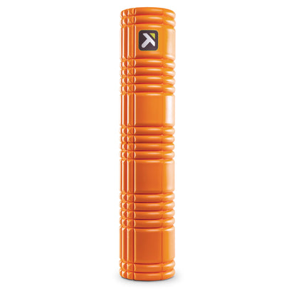 A foam roller rests upright in a gym environment, used for muscle relaxation and stretching.