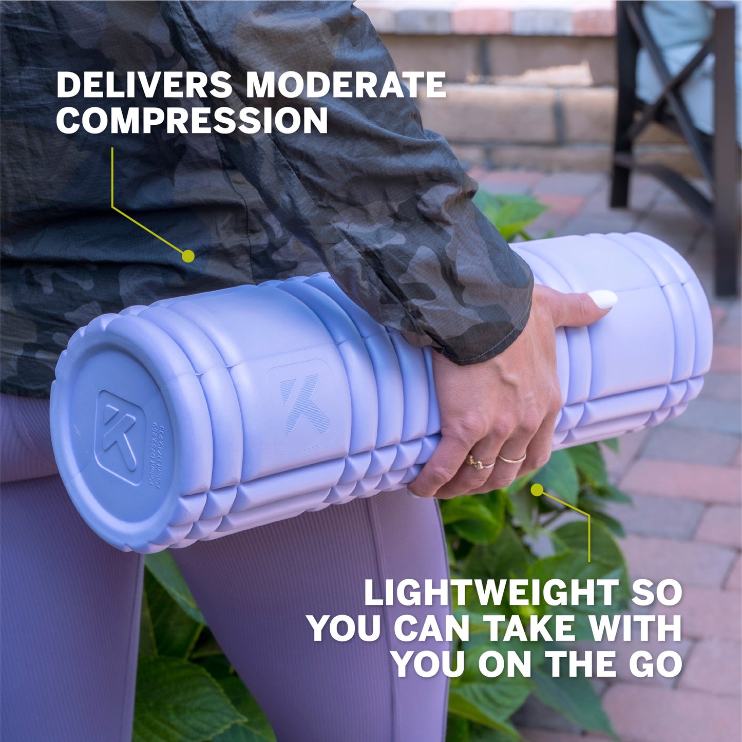 Person holds a lightweight foam roller for exercise in an outdoor setting.