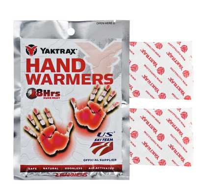 Packet of Yaktrax hand warmers releasing heat into a winter glove