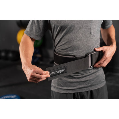 Person adjusts weightlifting belt in gym setting.