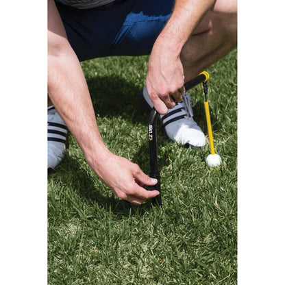 Player places a golf ball on a tee on the grass during a game or practice session