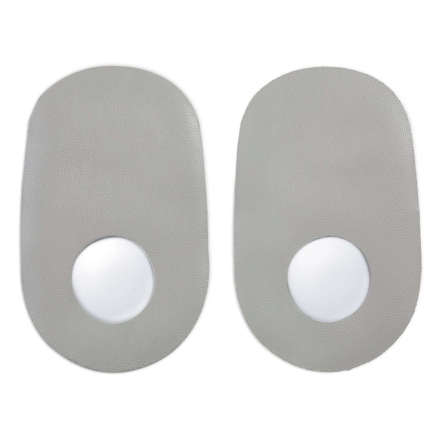 Two gray stickers with white centers are positioned side by side on a surface.