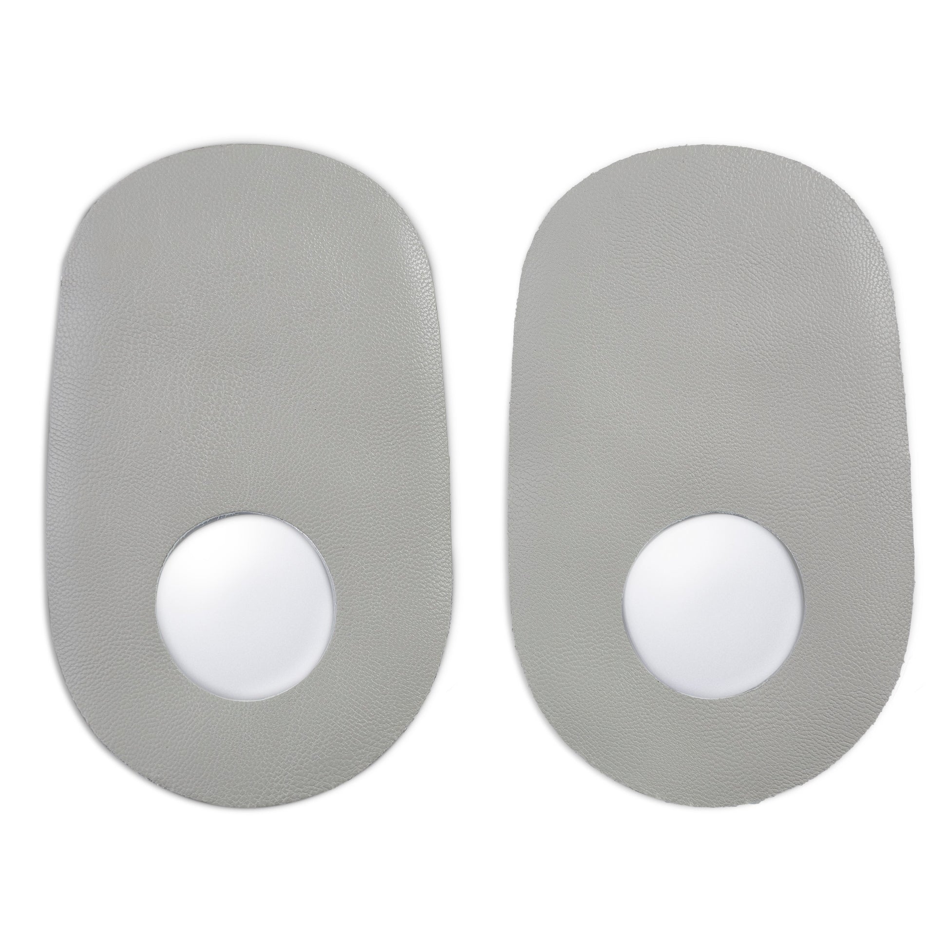 Two gray stickers with white centers are positioned side by side on a surface.