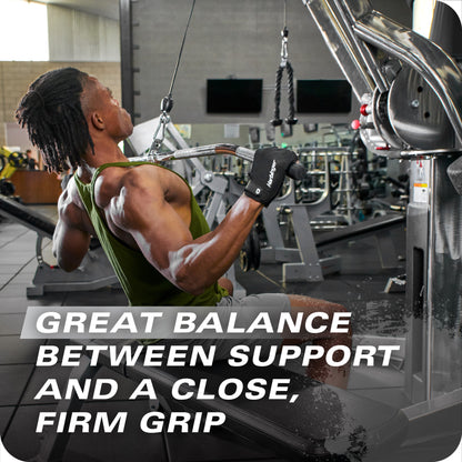 Man pulls cable on machine in gym amid fitness equipment and a wall with TVs