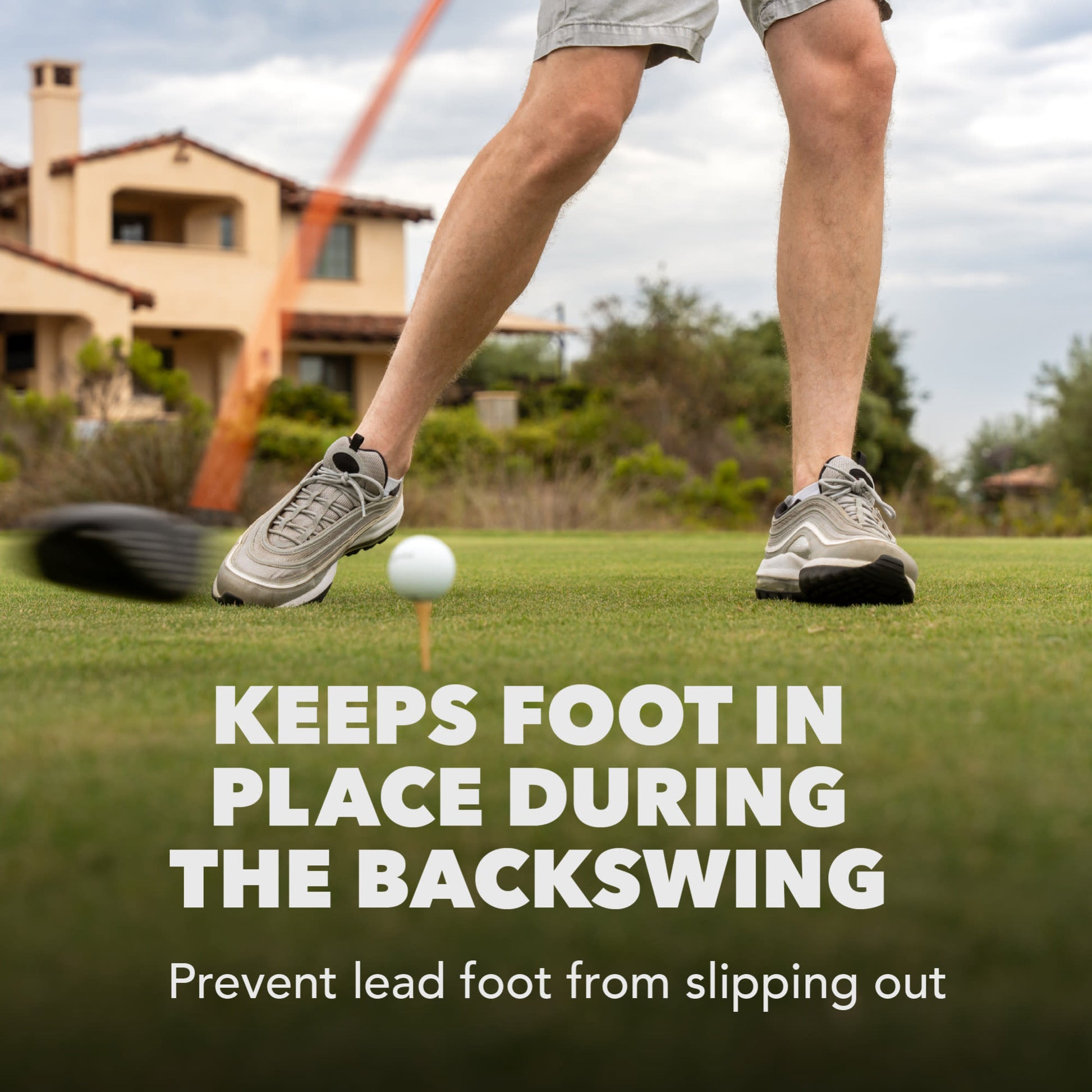 A person backswinging a golf club on a green lawn during daytime to prevent slipping.