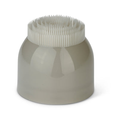 A grey ceramic holder with toothpicks inside in a white background.
