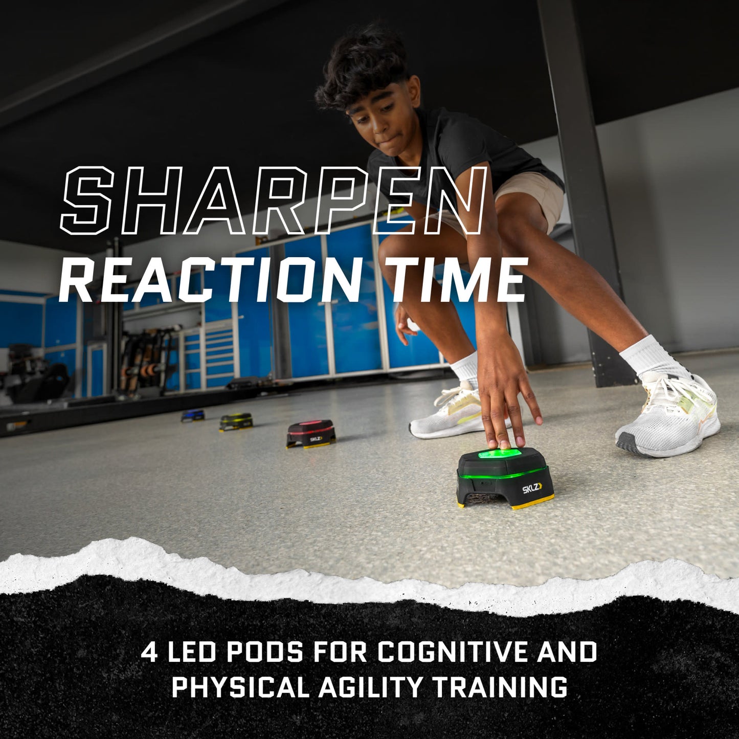 Boy interacts with a robotic device on the floor during indoor agility training session