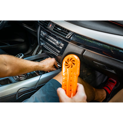 Person uses a fan device inside a car to cool the vehicle's interior.