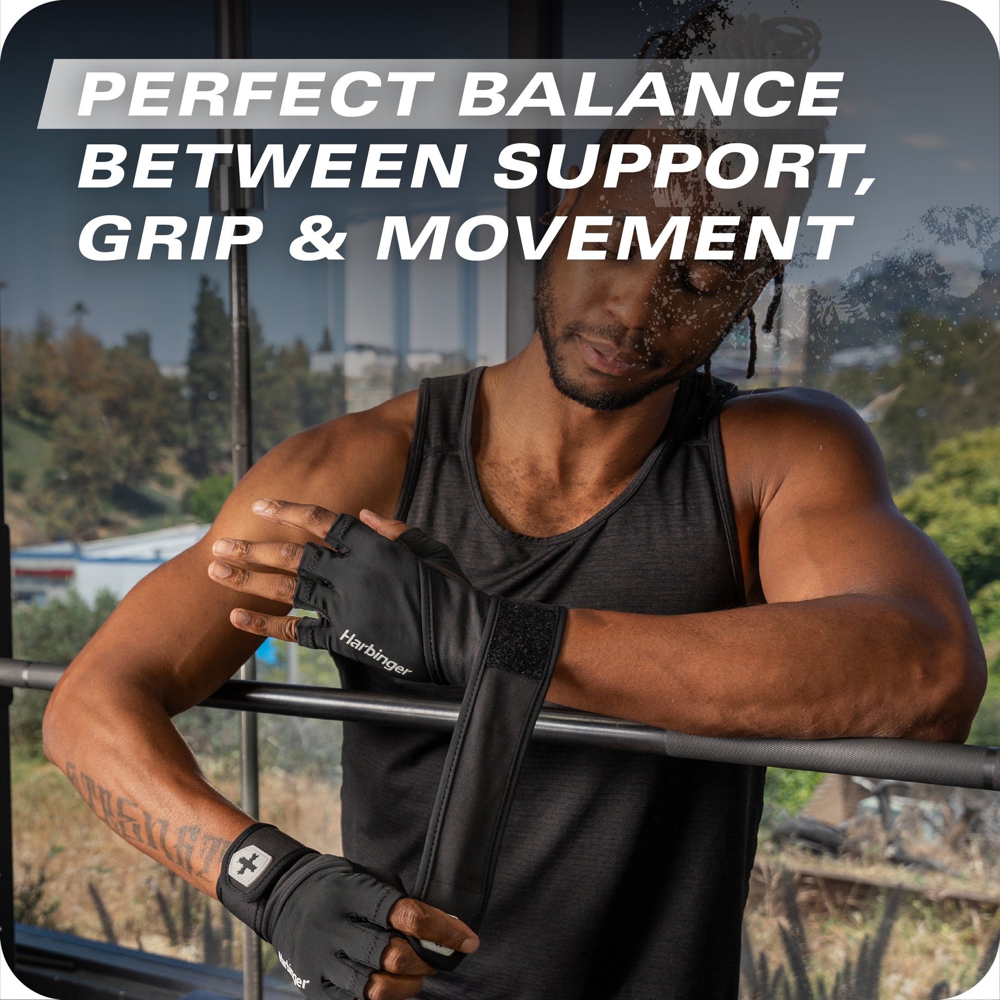 Man adjusts wrist support gloves amid outdoor workout environment.