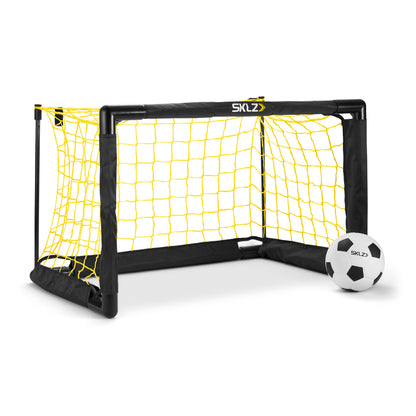 Mini soccer goal is set up with a ball nearby in a plain white background