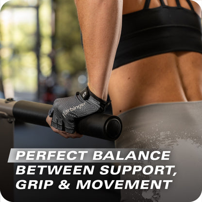 Gloved hand holds exercise bar, person stands in gym, blurred equipment in background.
