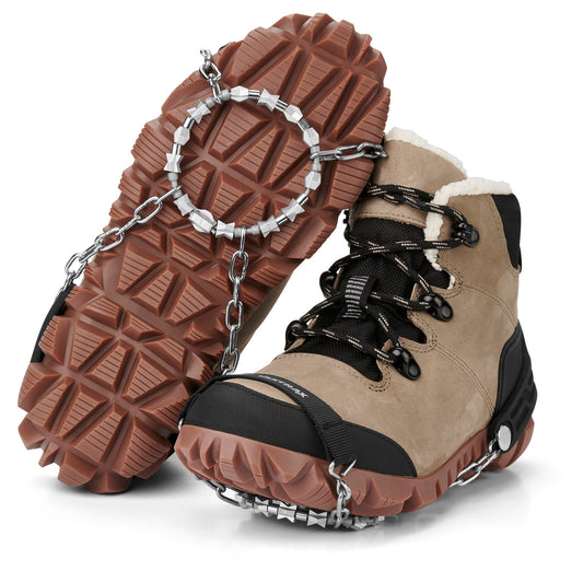 Hiking boots are fitted with snow chains for traction on icy terrain.