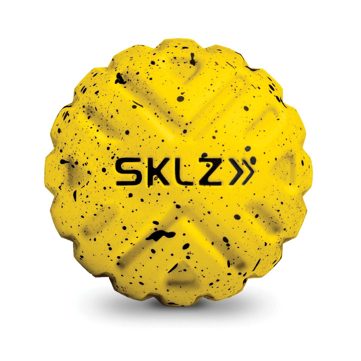 A yellow rubber ball with black speckles and the text SKLZ on its surface in a fitness environment